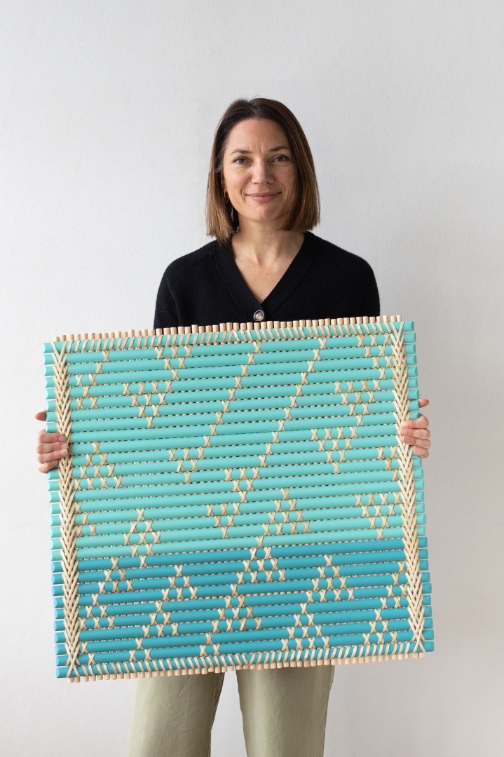 Veronica Stone holds her artwork 'Kāpuia ngā kākaho', commissioned by Studio Pacific.