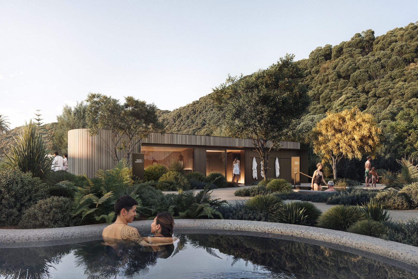 View toward the sauna and hammam pavilion, with cold pools nestled into native planting and framed by coastal bush.